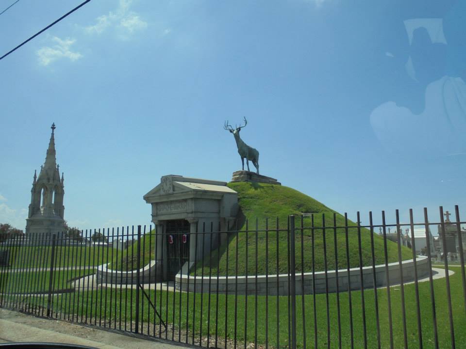 Elk monument standing atop a tumulus at the Greenwood Cemetery in New Orleans from outside the fence