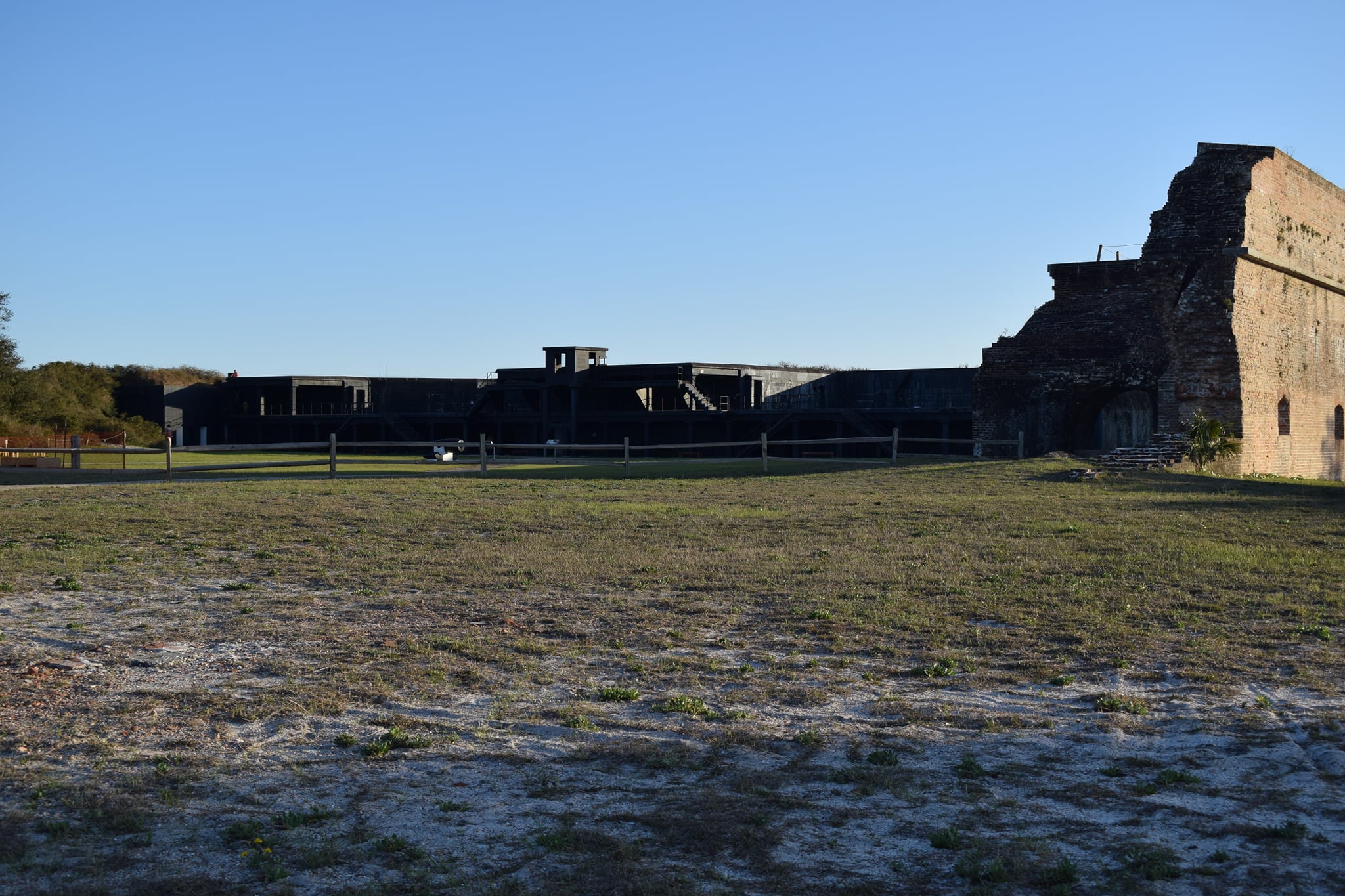 Sunlit brick walls of Fort Pickens on a clear, sunny day just before sunset.