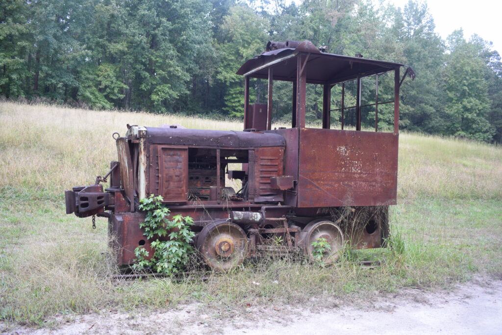 Abandoned industrial locomotive at West Blocton Coke Ovens Park in Alabama, a relic from the coal and steel boom now rusting in the grass.