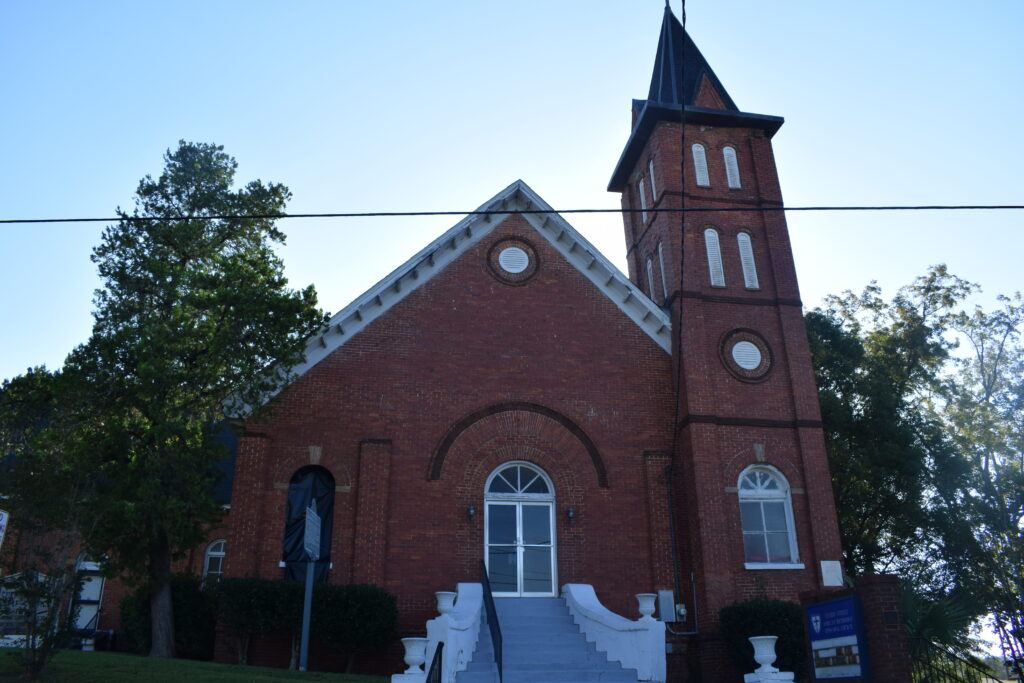 Front view of Cherry Street AME Church in Dothan, Alabama, showing the historic red-brick exterior and wide front steps beneath a clear morning sky.