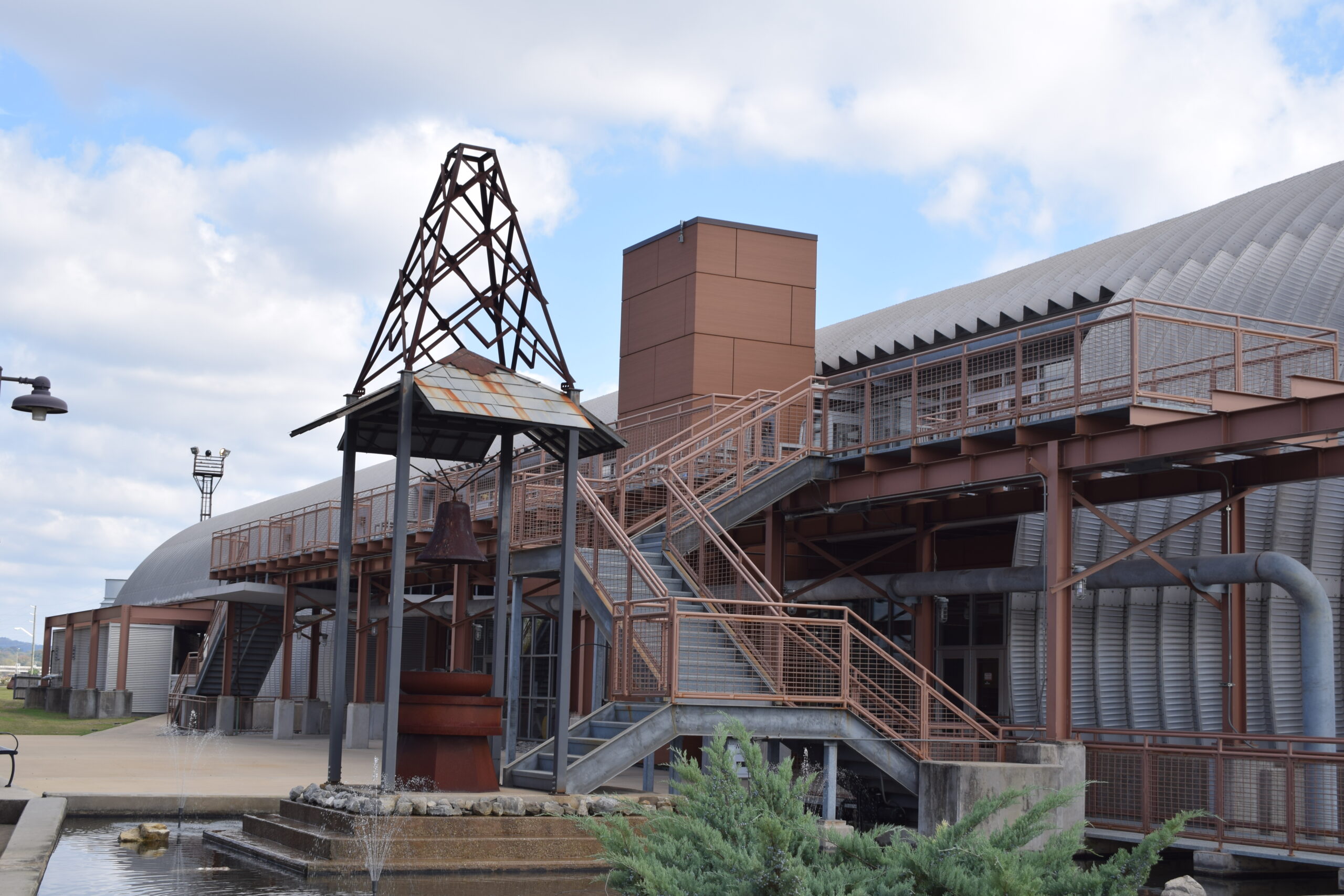 Entrance to Sloss Furnaces National Monument in Birmingham, Alabama, with rusted towers and catwalks visible beyond the gate
