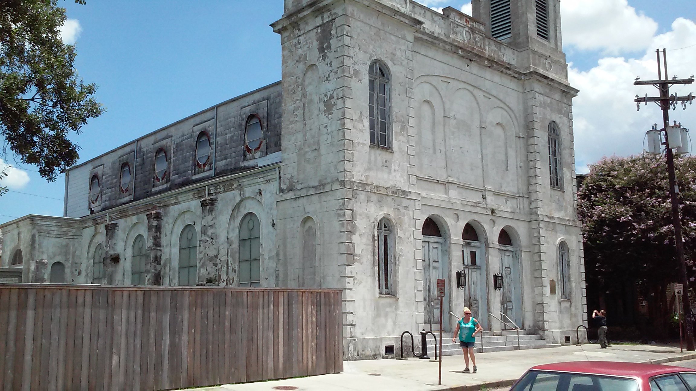 Front view of Holy Trinity Church in the Faubourg Marigny, an abandoned 19th-century German Catholic church with distinctive onion domes and worn brick façade.