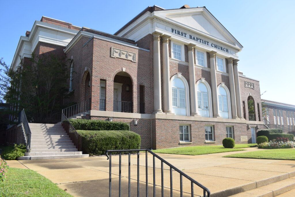 Angled view of First Baptist Dothan’s historic architecture, highlighting its brickwork and arched windows.