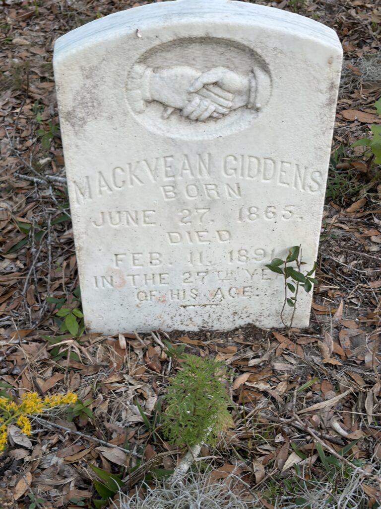 Headstone of Mackvean Giddens at Giddens Homestead Cemetery, featuring a carved clasped-hands motif symbolizing family and remembrance.