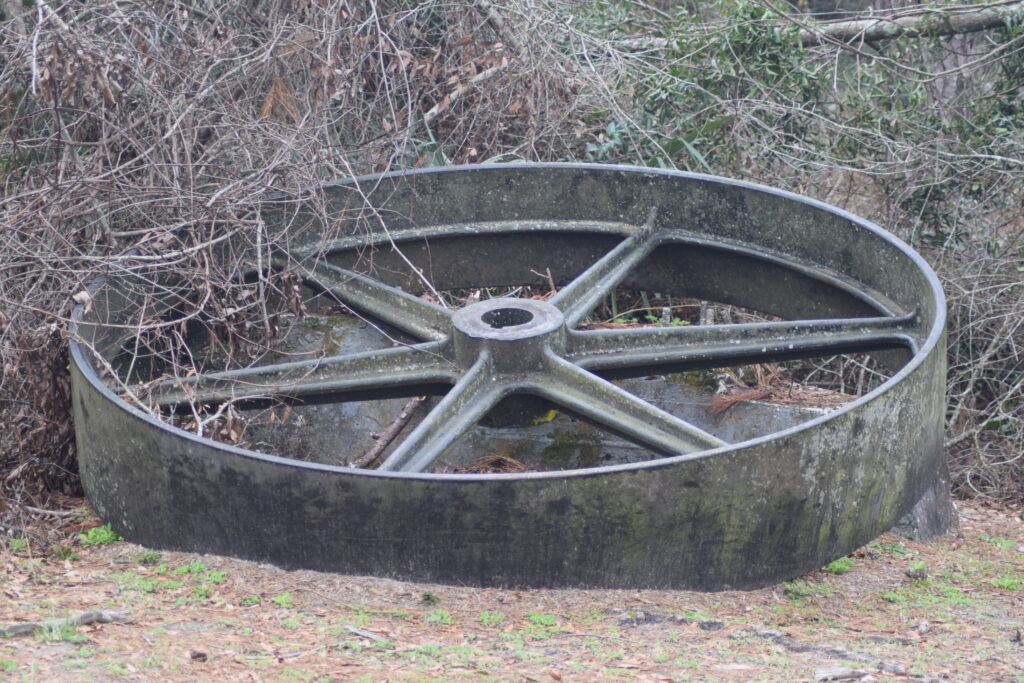 Historic flywheel from Ellaville’s sawmill on display at Suwannee River State Park, representing the town’s former lumber industry.