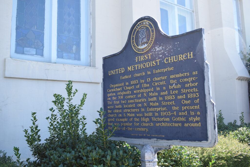 Alabama Historical Commission marker for First United Methodist Church in Enterprise, identifying it as the city’s earliest church, photographed beside the church building.