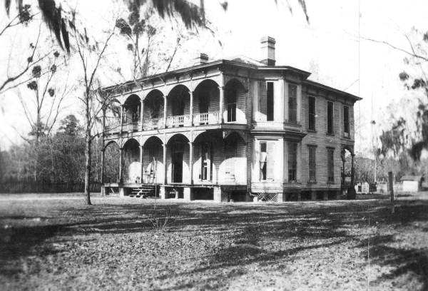Black-and-white image of the Drew Mansion in Ellaville, Florida, a large two-story residence with arched porches built by George Franklin Drew during the late 1800s.