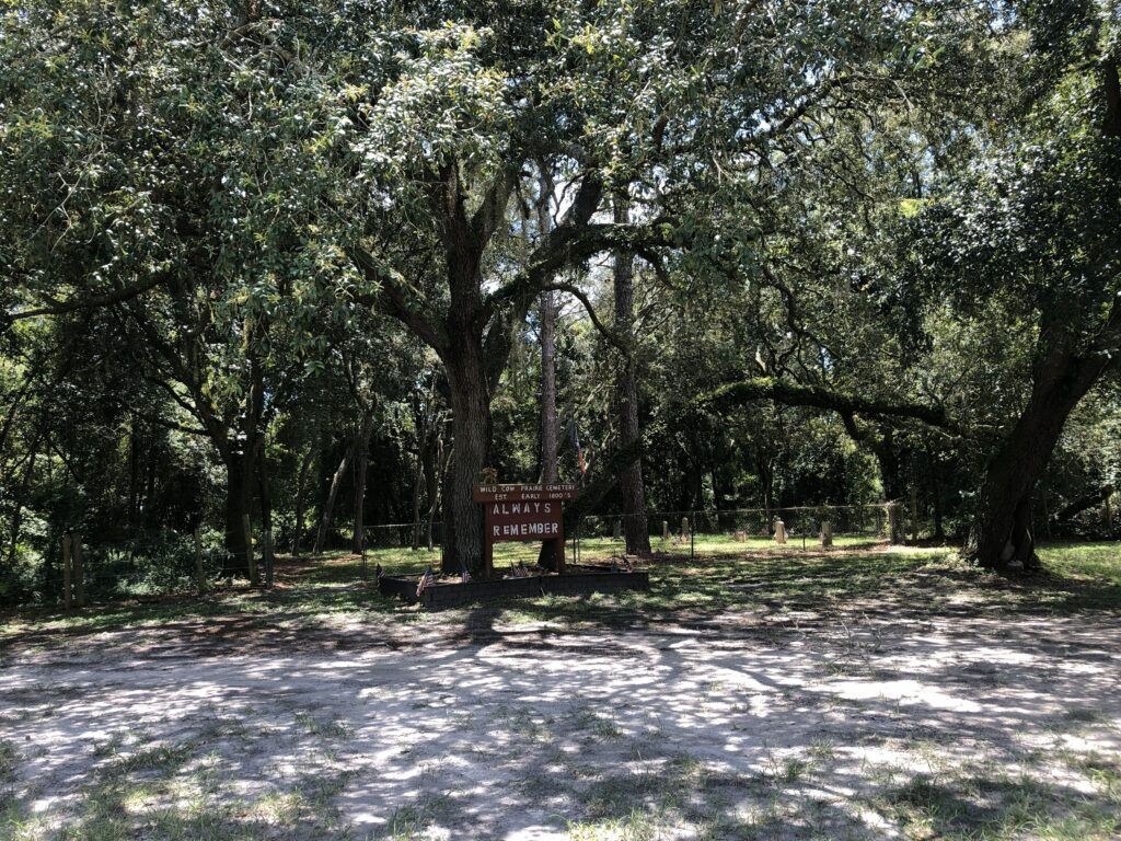 Wild Cow Prairie Cemetery in Sumter County, Florida, featuring a fenced historic burial ground surrounded by oak trees and shaded forest.