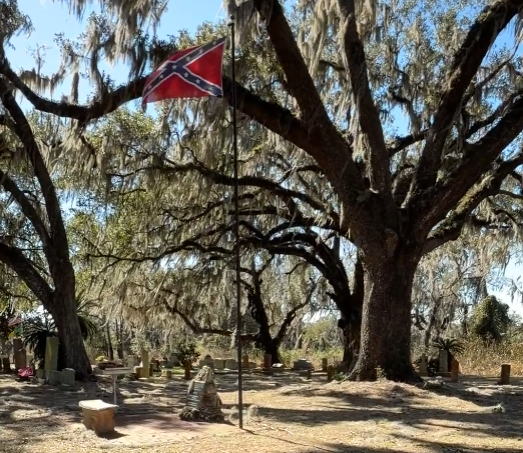 Wide view of Townsend House Cemetery in Pasco County, Florida, showing historic headstones beneath large live oak trees draped in Spanish moss.
