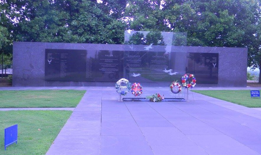 Wreaths placed before the memorial wall at the United States Air Force Memorial in Arlington, Virginia, honoring service and sacrifice beneath a quiet tree-lined backdrop.
