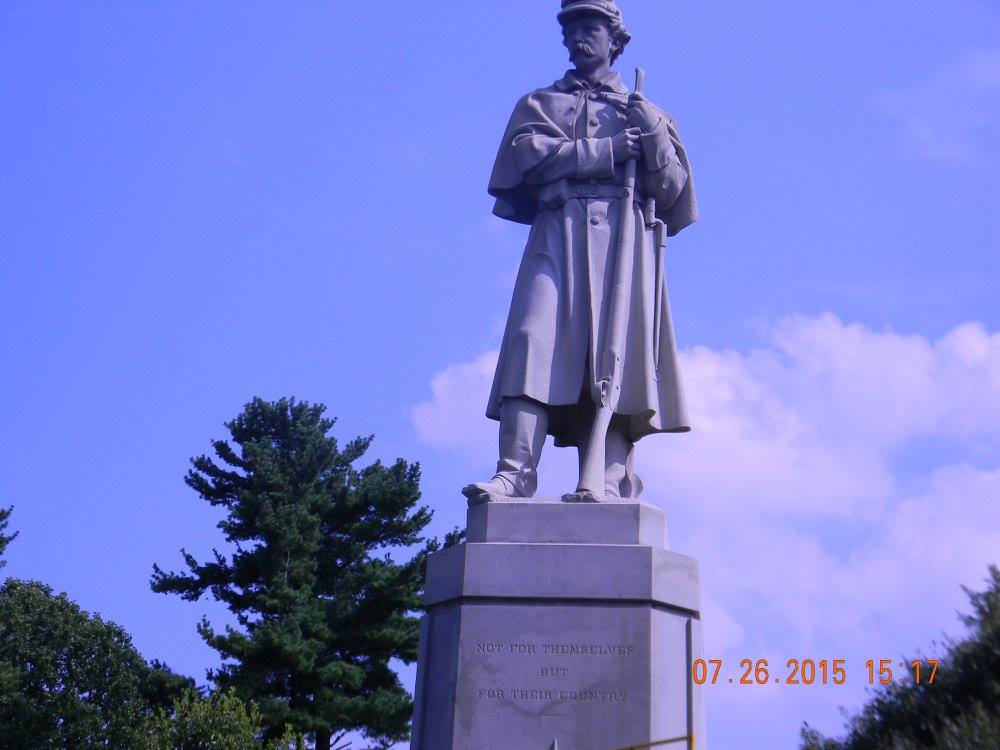 “Old Simon” statue at Antietam National Cemetery, a towering Union soldier standing watch over the graves with rifle in hand beneath an open sky