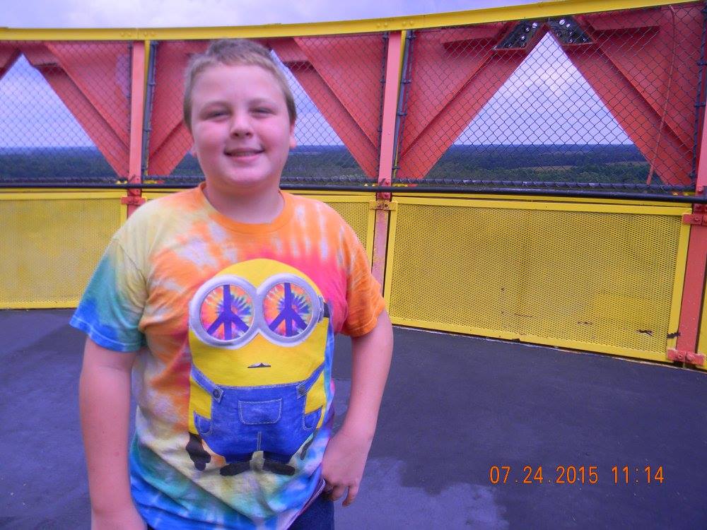 Boy standing at the top of the Sombrero Observation Tower at South of the Border in South Carolina with forest visible in the background