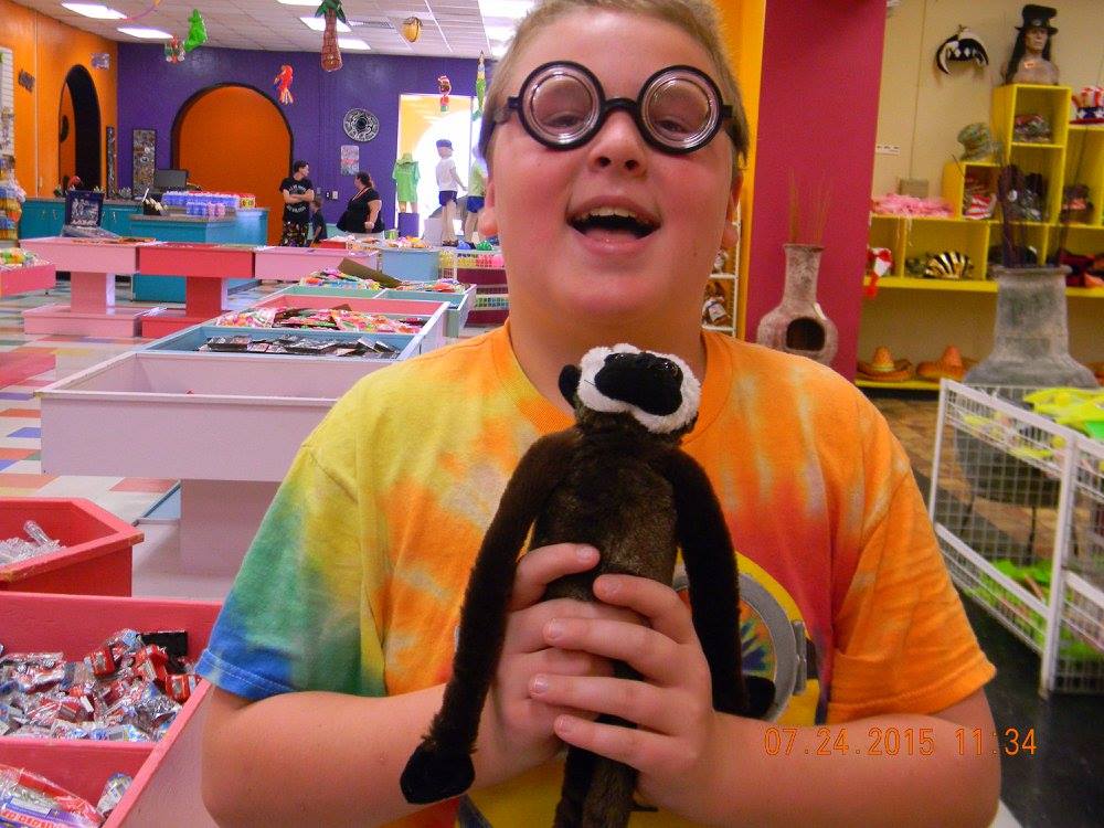 Boy wearing novelty goggles and holding a stuffed animal inside the South of the Border gift shop in South Carolina