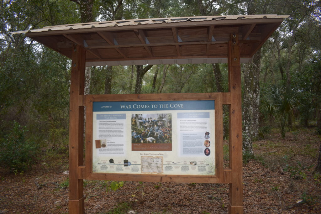 Interpretive sign about the Second Seminole War at Fort Cooper State Park in Florida, surrounded by wooded landscape