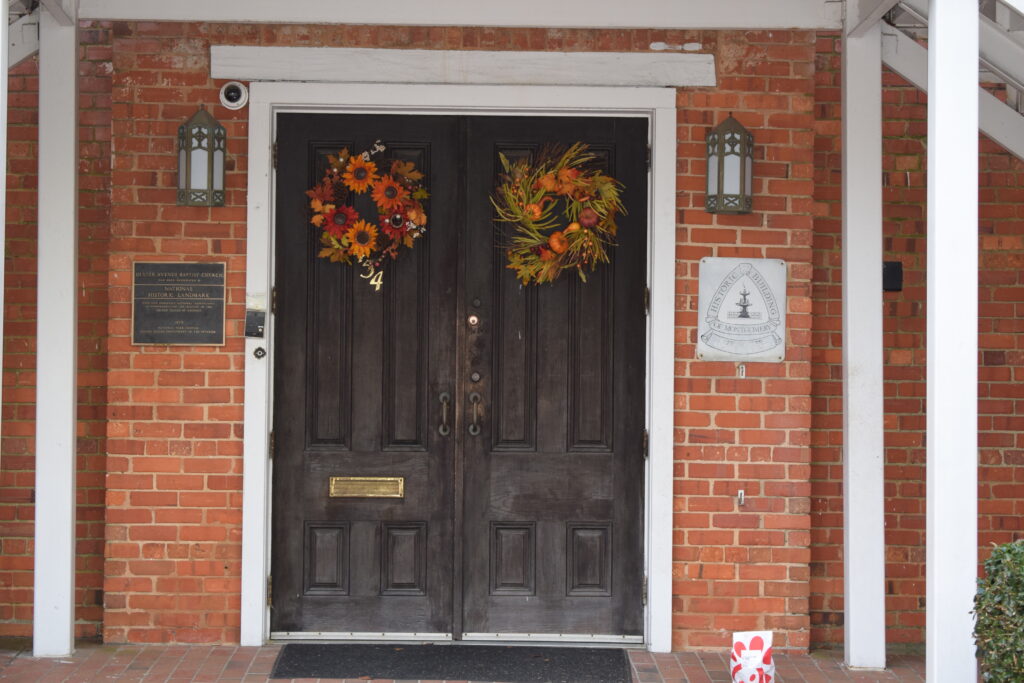 Front entrance doors of Dexter Avenue Baptist Church in Montgomery Alabama with historic landmark plaque and fall wreaths
