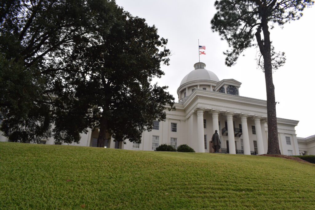 Alabama State Capitol building in Montgomery with white columns and dome viewed from the front staircase on Capitol Hill