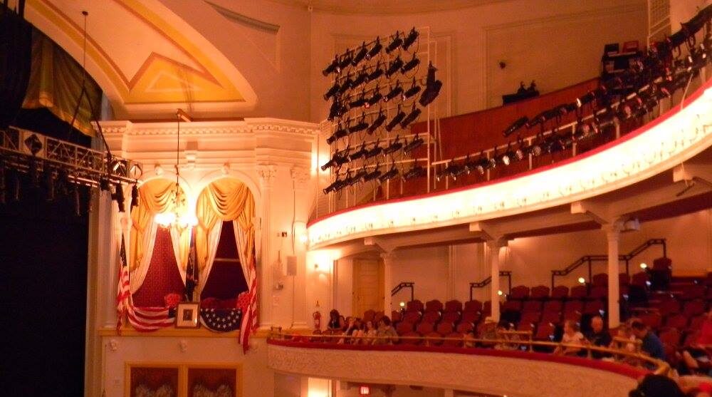 Audience seated in the balcony at Ford’s Theatre in Washington, D.C., with the presidential box where Abraham Lincoln was shot visible in the background