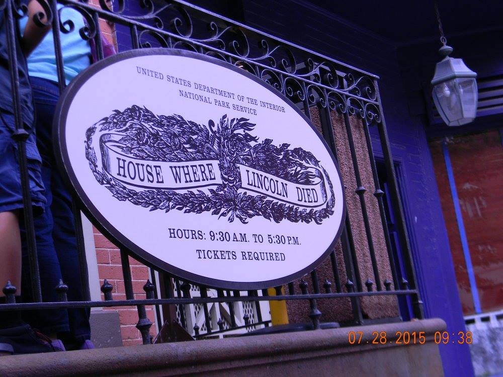Close-up of the National Park Service sign reading “House Where Lincoln Died” mounted on an iron railing outside the Petersen House in Washington, D.C.