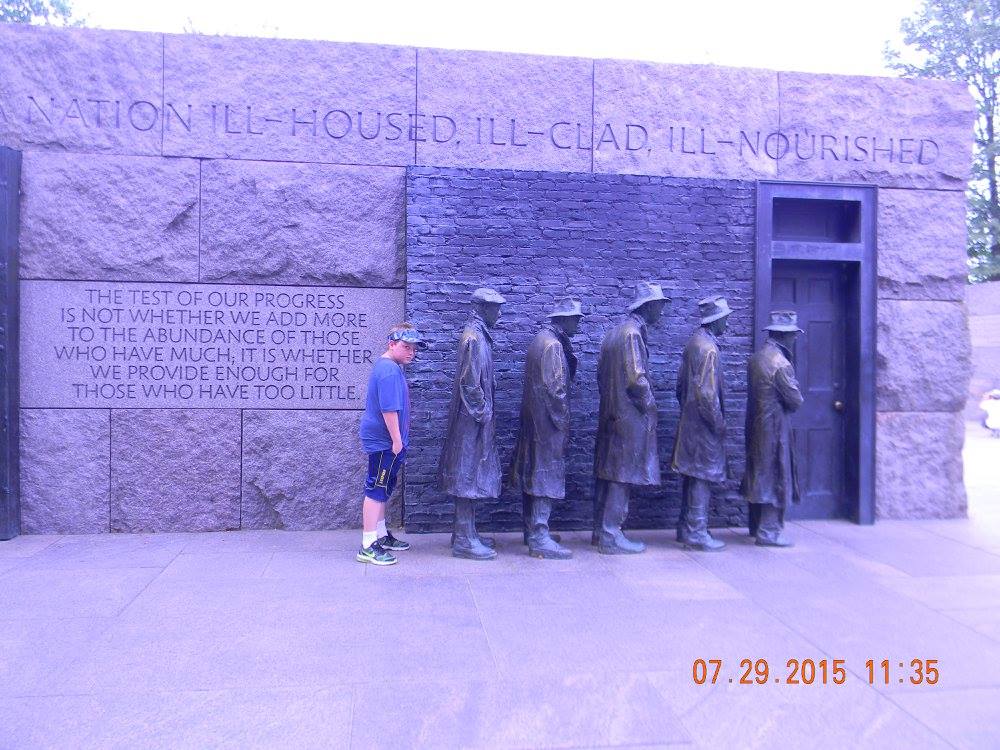A young visitor stands beside the breadline sculptures at the Franklin Delano Roosevelt Memorial in Washington, D.C.