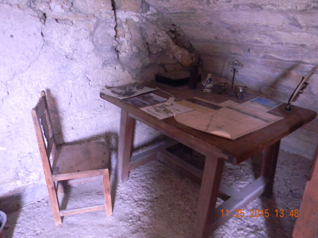A reconstructed wooden desk and chair inside the coquina stone interior of Fort Matanzas National Monument, showing how Spanish soldiers lived and worked.