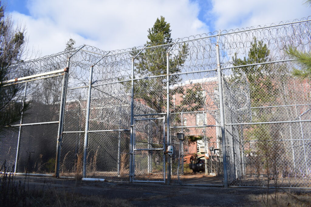 Security fencing topped with razor wire surrounds the abandoned Rivers State Prison on the Central State Hospital campus in Milledgeville, Georgia.