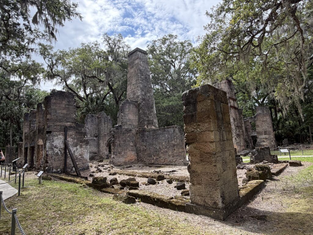 The towering coquina stone ruins of the Bulow Plantation sugar mill surrounded by moss-covered live oaks in Flagler Beach, Florida.