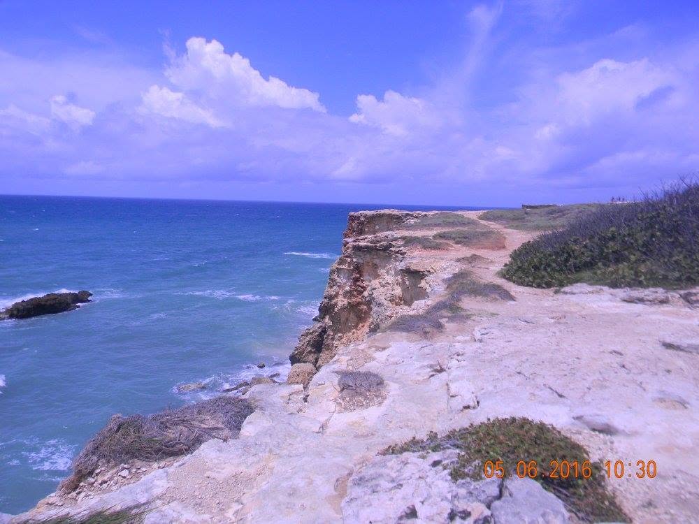 Rocky limestone cliffs overlooking the blue Caribbean Sea near Los Morrillos Lighthouse in Cabo Rojo, Puerto Rico.