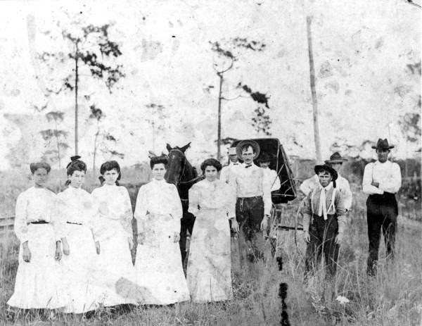 Historic photograph of Brewster, Florida residents gathered beside a horse-drawn carriage during the community’s early years.