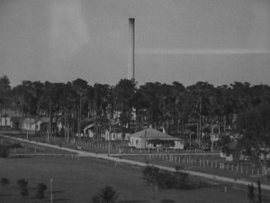 Historic view of homes and streets in the Brewster, Florida phosphate company town with the power plant smokestack visible in the distance.