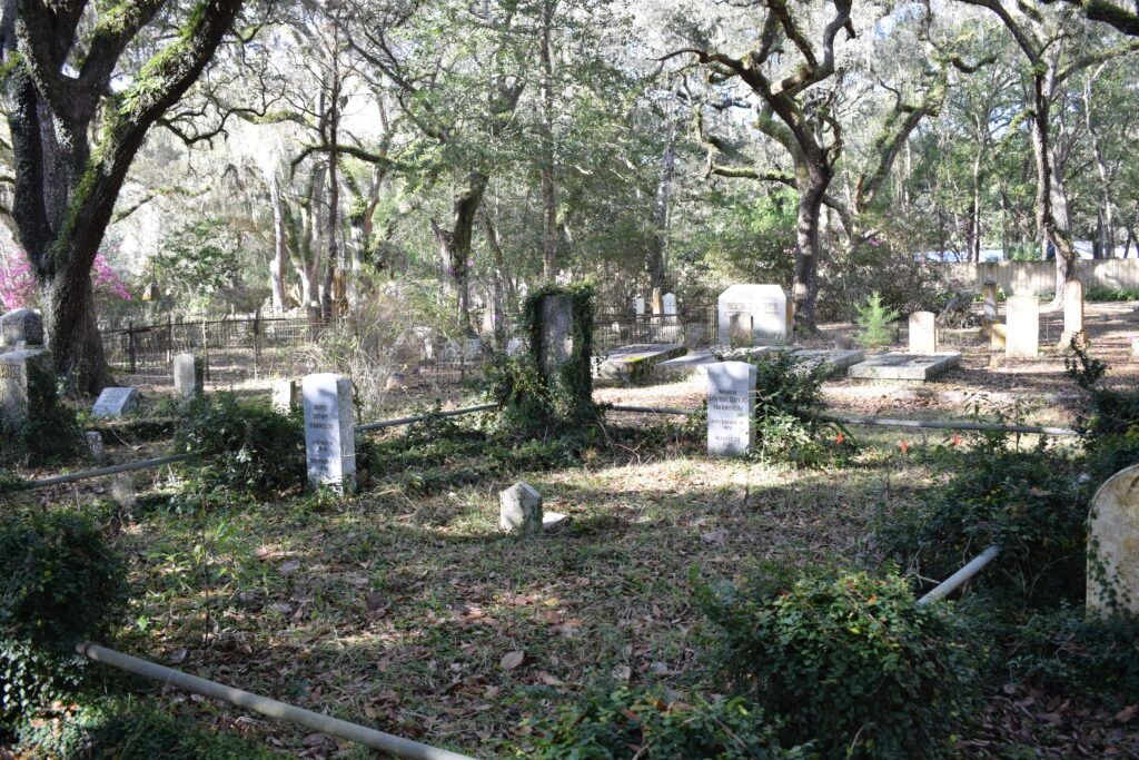 Historic headstones and family plots beneath live oak trees at Micanopy Historic Cemetery in Florida