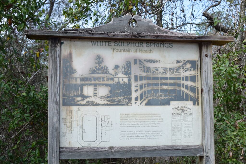Interpretive sign showing historic photographs, a floor plan, and an advertisement for the White Sulphur Springs bathhouse in Florida.
