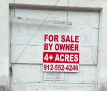 For Sale by Owner sign on the closed Dead People’s Things for Sale antique shop in Woodbine, Georgia