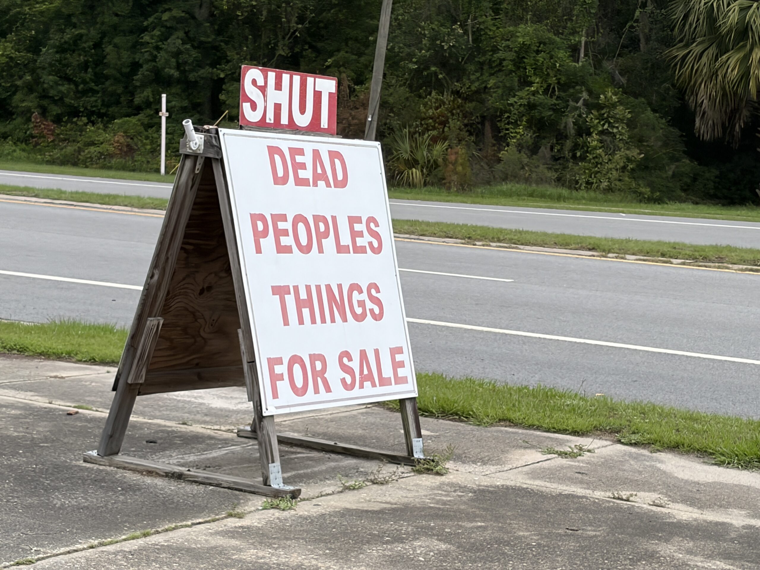 Dead People’s Things for Sale roadside sign with a SHUT sign above it in Woodbine, Georgia