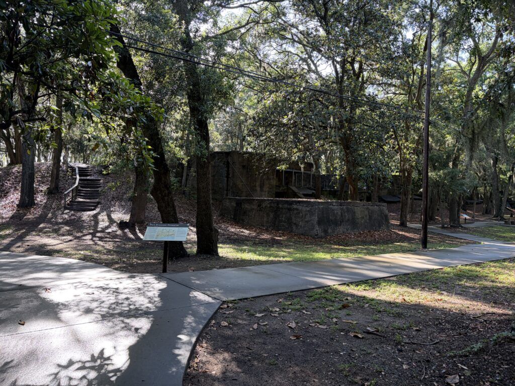 Quiet concrete ruins of Fort Fremont surrounded by trees and empty walking paths on St. Helena Island, South Carolina.