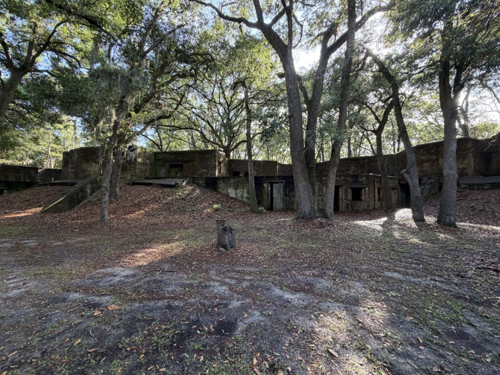 Wide view of the surviving concrete fortifications at Fort Fremont beneath live oak trees on St. Helena Island, South Carolina.