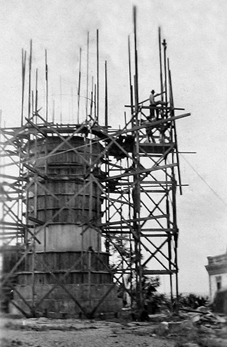 Historic photograph of the new Punta Higüero Lighthouse under construction with wooden scaffolding in Rincón, Puerto Rico.