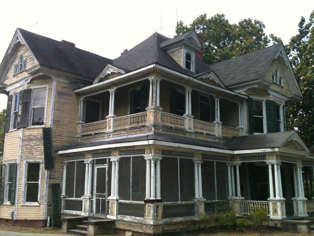 Luther Henry Caldwell House in Lumberton, North Carolina, showing weathered siding, peeling paint, and deterioration before restoration.