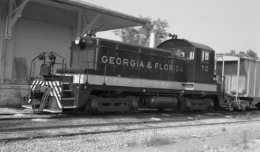 Historic Georgia & Florida Railroad locomotive numbered 70 stopped beside a railroad building.