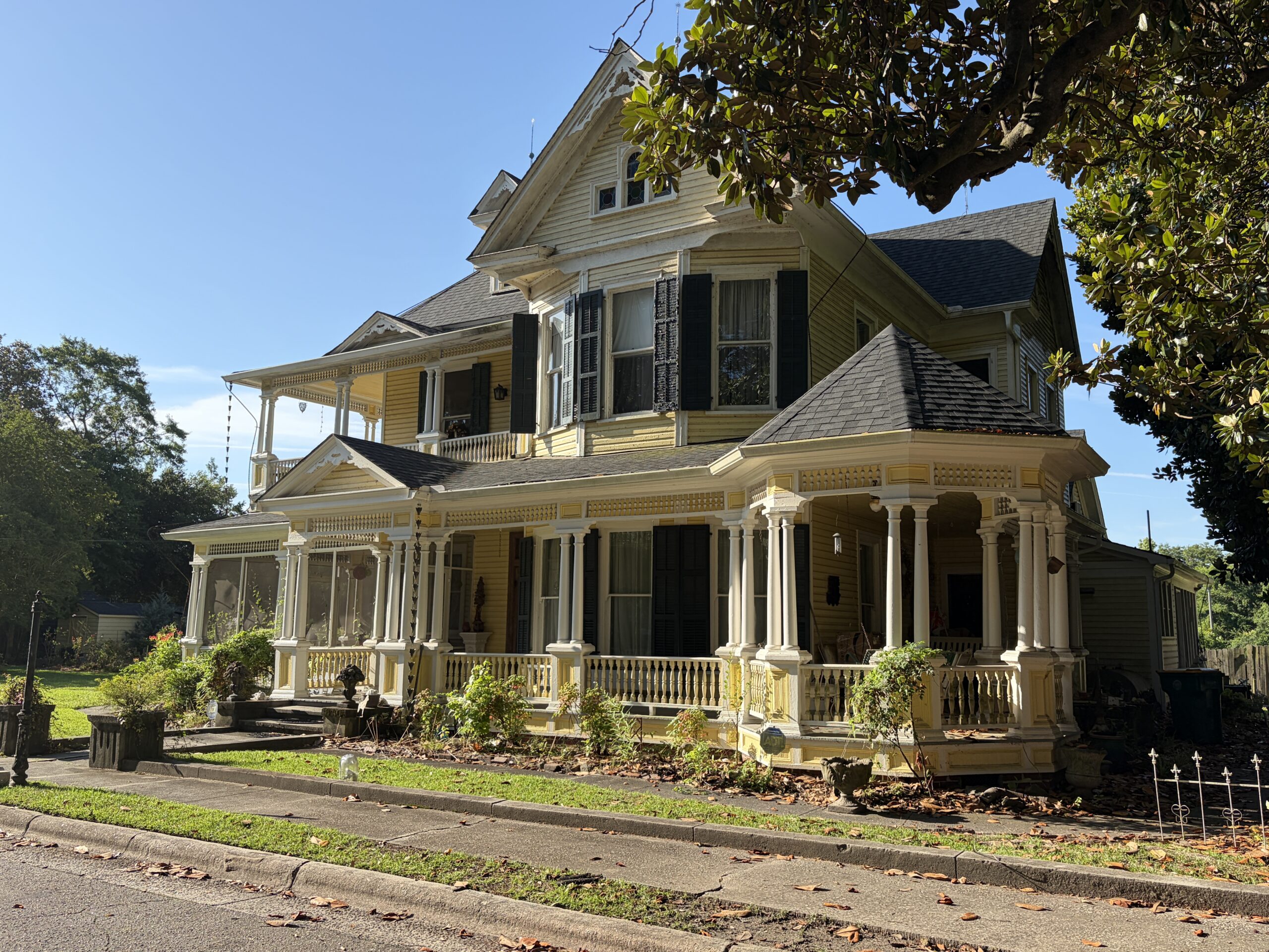 Historic Luther Henry Caldwell House in Lumberton, North Carolina, featuring an elaborate wraparound porch and Queen Anne architectural details.