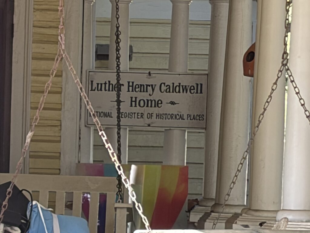 Sign on the porch identifying the Luther Henry Caldwell Home in Lumberton, North Carolina, as a National Register of Historic Places property.