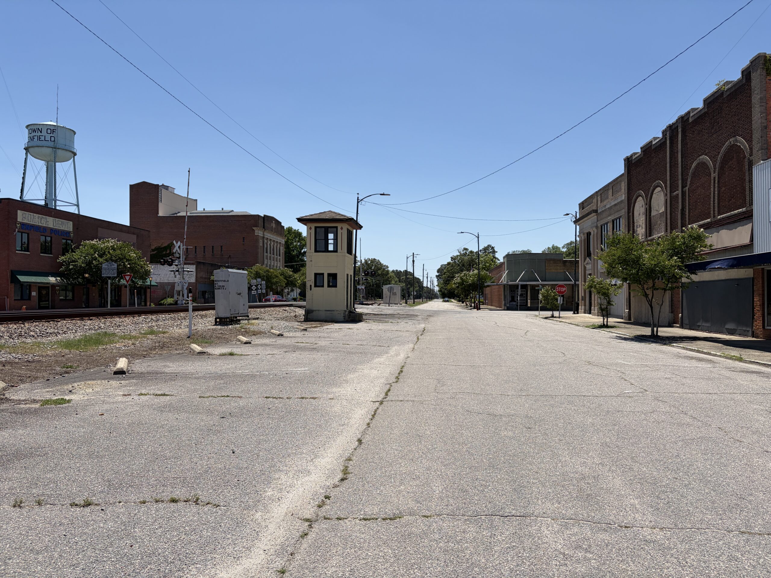 Historic downtown Enfield, North Carolina, with railroad tracks, old brick storefronts, and the Town of Enfield water tower.