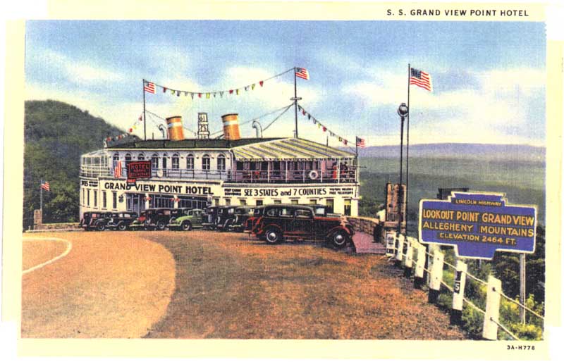 Vintage color postcard showing Pennsylvania's Grand View Ship Hotel decorated with American flags and pennants, with 1930s automobiles parked outside along the Lincoln Highway.