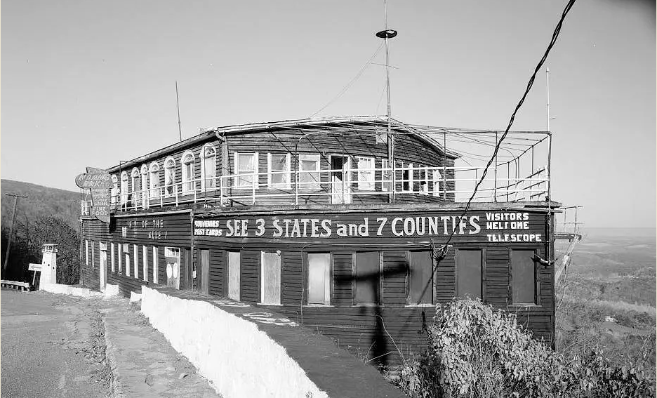 Historic black-and-white photograph of the Grand View Ship Hotel with wooden siding, enclosed lower windows, an upper observation deck, and a large sign advertising views of three states and seven counties.
