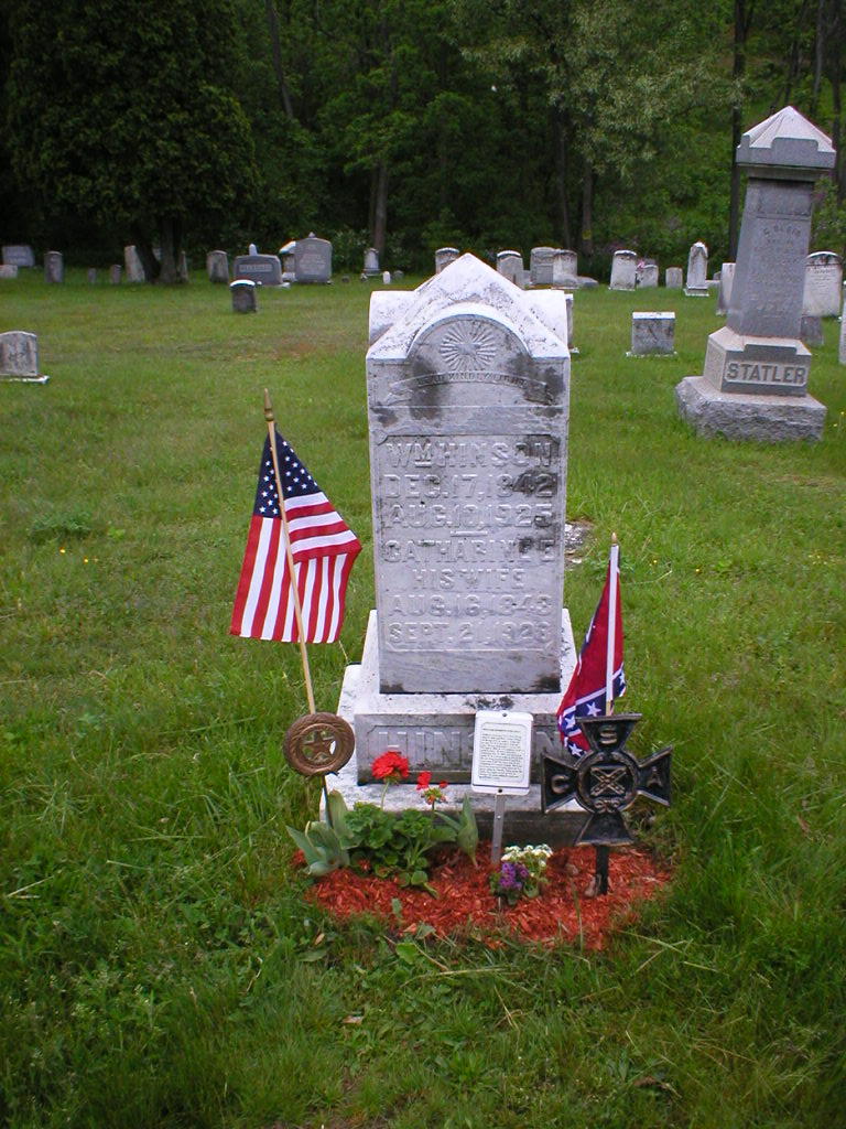 Gravestone of William S. Hinson, also associated with the name Oliver Perry Niley, decorated with American and Confederate flags, flowers, and veterans' memorial markers at Schellsburg Union Cemetery in Pennsylvania.