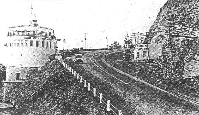 Historic black-and-white photograph of the Grand View Ship Hotel beside a winding section of Pennsylvania's Lincoln Highway, with vintage automobiles and a mountainside service station.